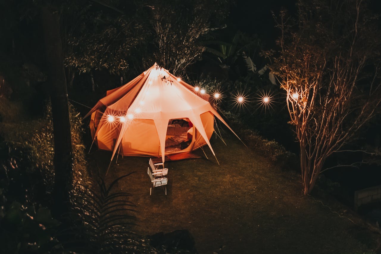 Illuminated tent setup for a cozy camping night in a São Paulo garden.